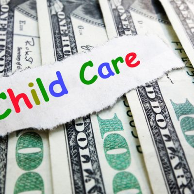 Child Care text in colorful letters on money -- cost of daycare concept