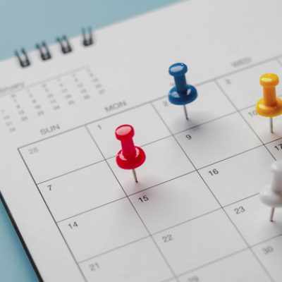 Embroidered red pins on a calendar event Planner calendar,clock to set timetable organize schedule,planning for business meeting or travel planning concept.
